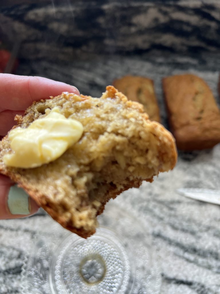sliced and bitten banana bread with butter on top